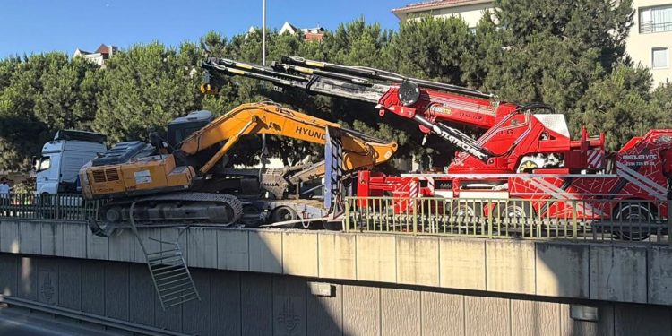 Tırın üzerinden düşen ekskavatör korkuluklarda asılı kaldı